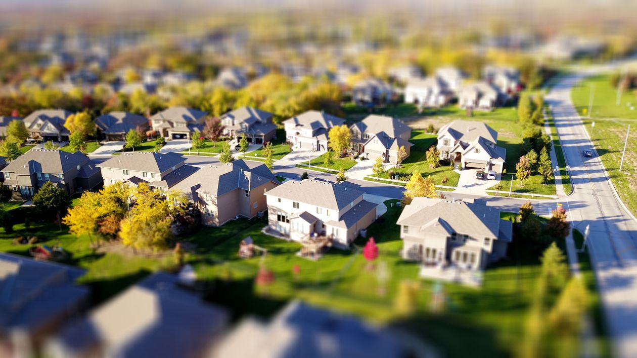 Close-up of a real estate agent's hand giving house keys to a new homeowner in a bright, modern setting, representing a successful transaction.